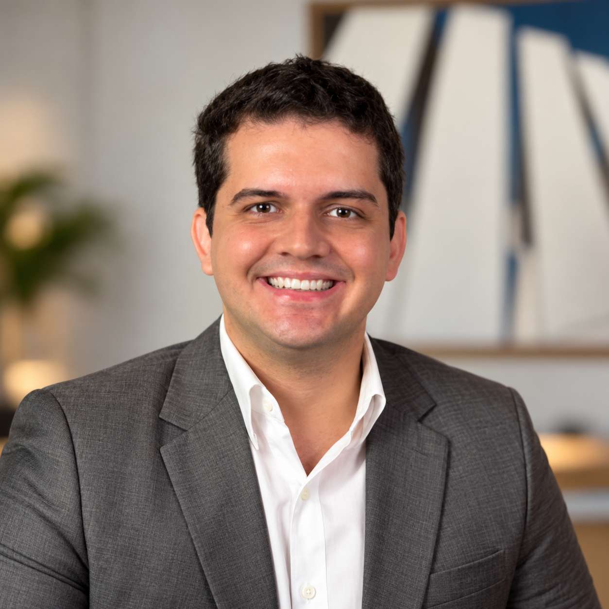 Retrato de Guilherme Tedgue com blazer cinza e camisa branca